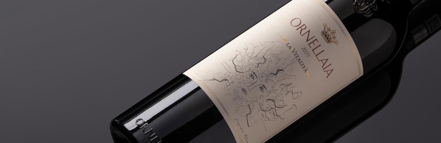 Eine Weinflasche liegt auf einem schwarzen Untergrund. Das Etikett zeigt eine künstlerische Darstellung mit dem Namen -Ornellaia 2022 La Vitalità-. Die Flasche hat eine elegante Form.