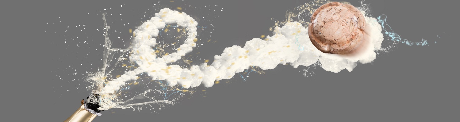 Eine Sektflasche sprudelt, wobei Schaum und Wasserfontänen in alle Richtungen spritzen. Eine Eiskugel wird von dem Sprudel umgeben, während Hintergrund in grauer Farbe gehalten ist.