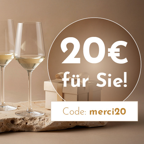 Zwei Weingläser stehen auf einem rustikalen Untergrund. Im Hintergrund befindet sich ein Geschenk. Darauf steht der Text: -20€ für Sie! Code: merci20-.