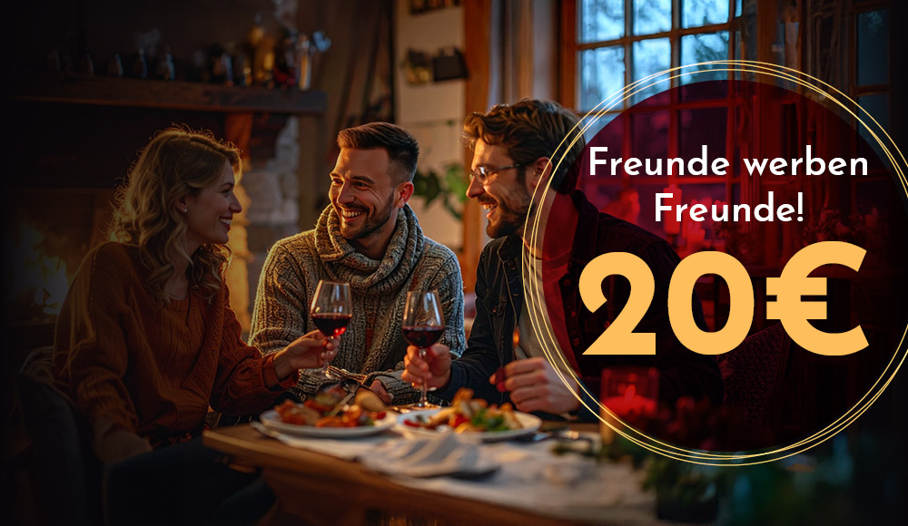 Drei Freunde sitzen an einem Tisch, genießen Essen und Wein und lachen. Im Hintergrund ist ein Kamin sichtbar. Text: -Freunde werben Freunde! 20€-.