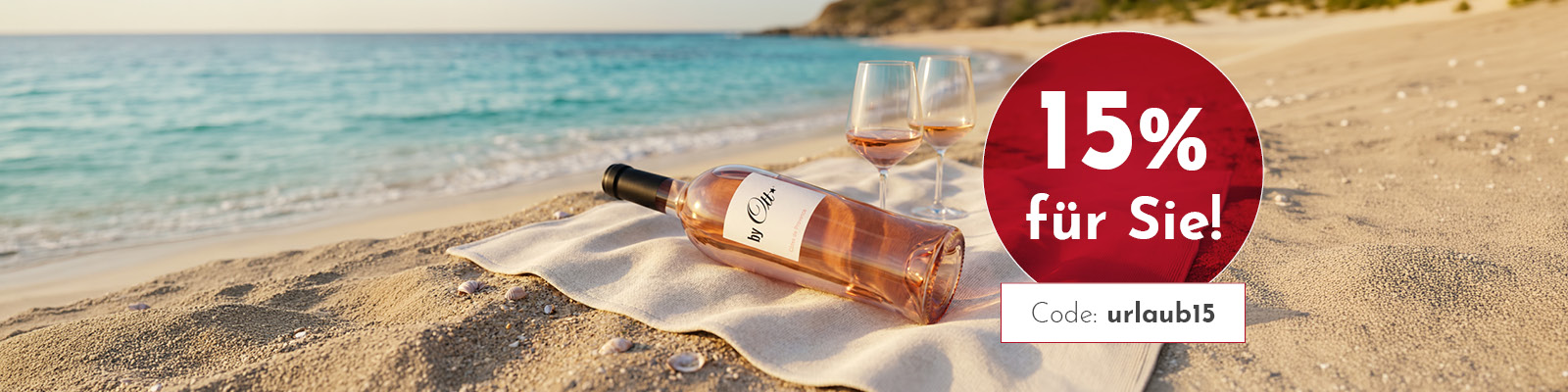Eine Flasche Roséwein liegt auf einem Sandstrand neben zwei Gläsern, umgeben von sanften Wellen und Muscheln. Der Text bewirbt einen 15%-Rabatt mit dem Code -urlaub15-.