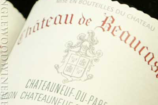 Eine Weinetikette zeigt den Text -Château de Beaucastel- in eleganter Schrift. Unter dem Namen steht -Châteauneuf-du-Pape-, umgeben von einem Wappen. Der Hintergrund ist schlicht und hell.