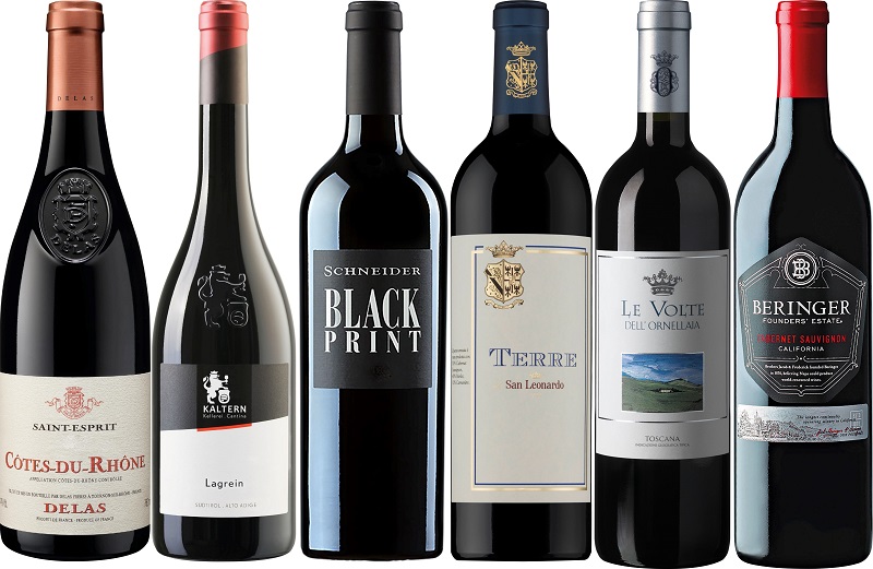 Weinpaket Rotwein Bestseller Sechs Flaschen Rotwein sind nebeneinander angeordnet. Jede Flasche hat ein einzigartiges Etikett mit verschiedenen Namen und Designs, die jeweils für eine bestimmte Weinregion oder Marke stehen.