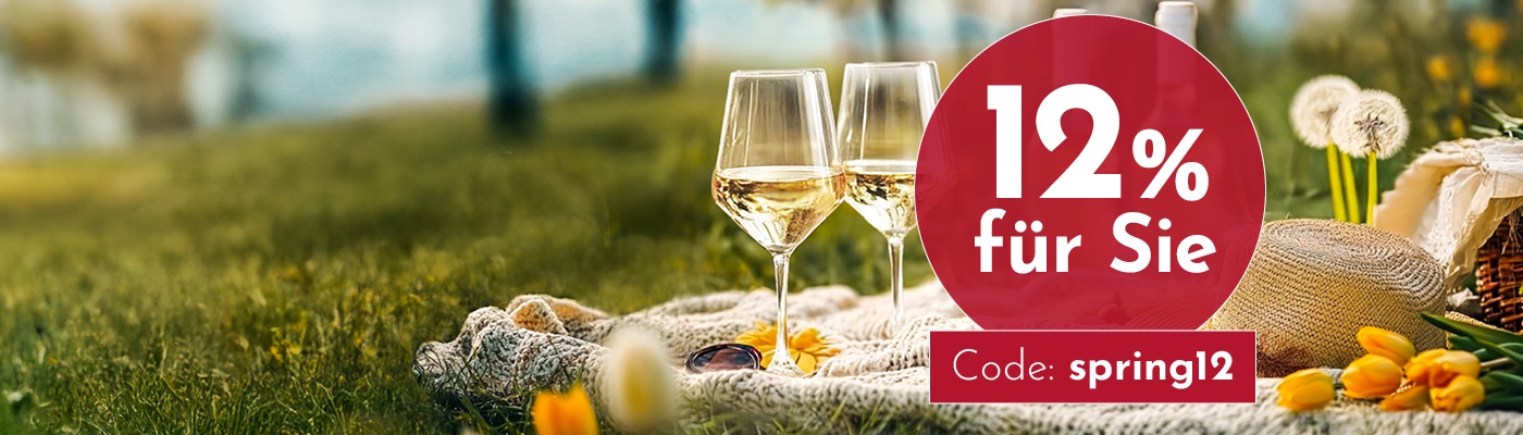 Zwei Gläser Weißwein stehen auf einer Decke im Gras, umgeben von Blumen. Ein Angebot von 12 % Rabatt wird angezeigt, mit dem Code -spring12-.