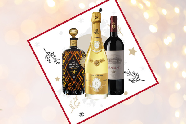 Drei Flaschen alkoholischer Getränke stehen im Vordergrund: eine Grappa-Flasche, eine Champagnerflasche und eine Rotweinflasche. Der Hintergrund ist festlich mit goldenen Lichtern und dekorativen Elementen.