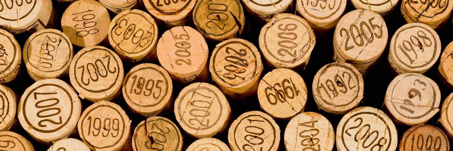 Eine Vielzahl von Korken aus Weinflaschen liegt nebeneinander, die Jahreszahlen von 2002 bis 2015 sind deutlich eingeprägt. Hintergrund und Umgebung sind unscharf, was den Fokus auf die Korken lenkt.