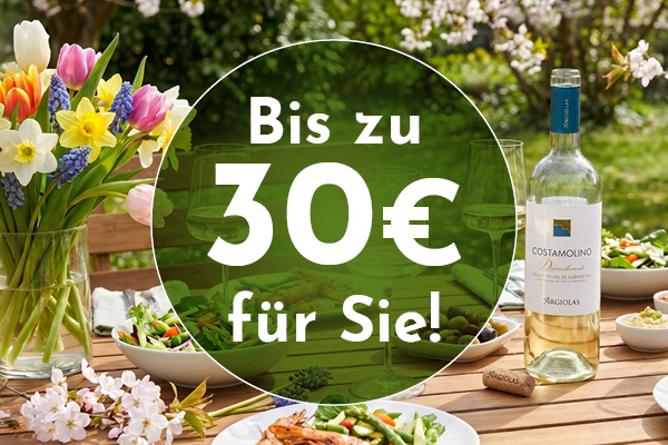 Ein Tisch im Freien ist mit frischen Blumen, zwei Weingläsern und verschiedenen Salatschalen dekoriert. Eine Flasche Wein steht daneben. Auf einem Banner steht: -Bis zu 30€ für Sie!-
